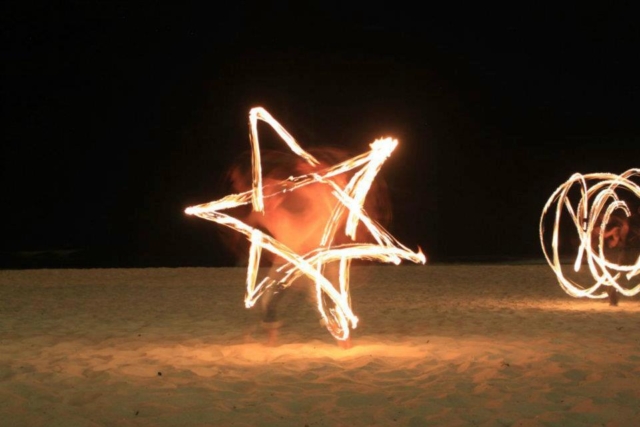 Duncan Greenwood practicing anti-spin flower patterns with fire flower sticks - slow shutter photography. - Flow DNA